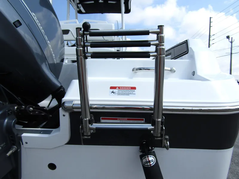 Slide: The Image of 2024 Wellcraft 202 Fisherman boat ladder and engine detail under a blue sky. - 3
