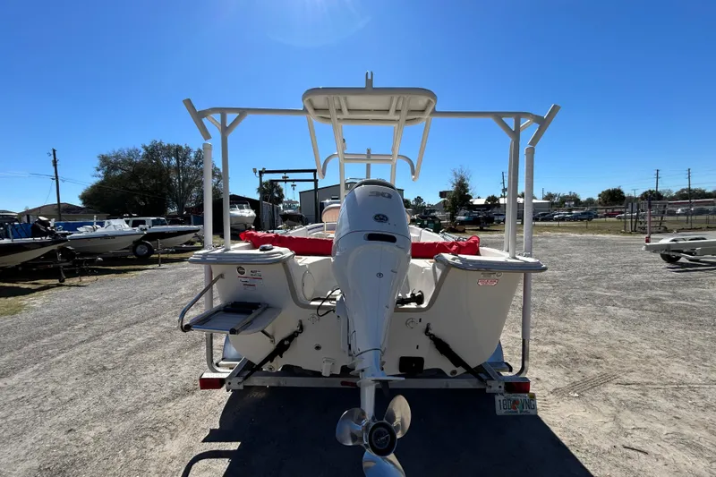 Slide: The Image of 2020 Carolina Skiff 178 DLV boat with outboard motor, parked outdoors under clear blue sky. - 3