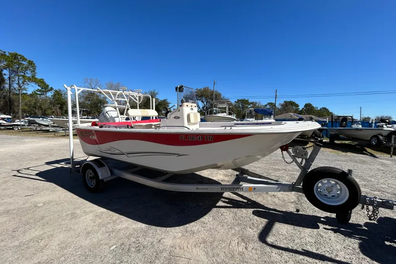 Slide: The Image of 2020 Carolina Skiff 178 DLV boat on trailer, parked outdoors under clear blue sky. - 5