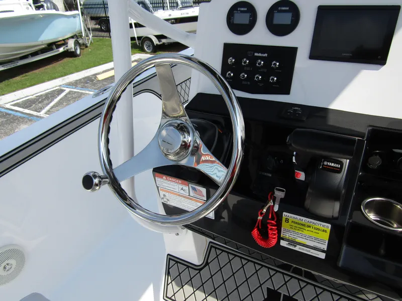 Slide: The Image of 2024 Wellcraft 202 Fisherman boat dashboard with steering wheel and control panel. - 19