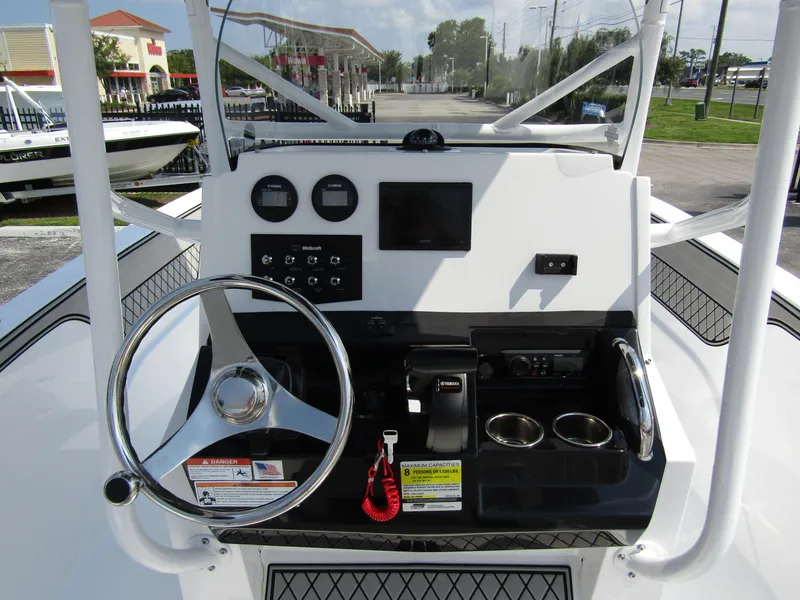 Slide: The Image of 2024 Wellcraft 202 Fisherman boat dashboard with steering wheel and controls. - 14