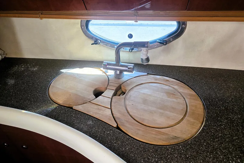 Slide: The Image of Kitchen sink area on a 1999 Fairline Targa 43 yacht with wooden covers. - 17