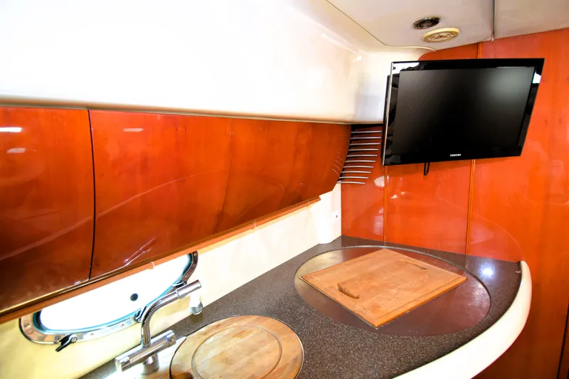 Slide: The Image of 1999 Fairline Targa 43 yacht interior with wooden cabinetry and mounted TV. - 2