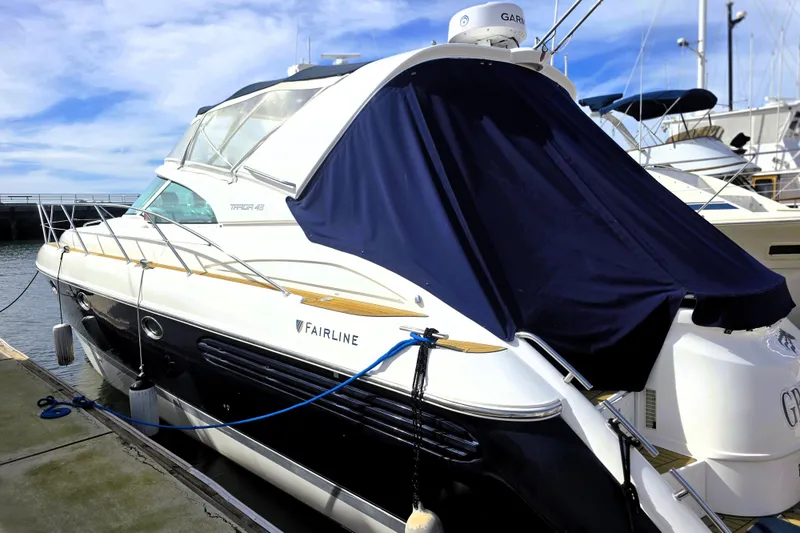 Slide: The Image of 1999 Fairline Targa 43 yacht docked at marina, covered with navy blue tarp. - 35