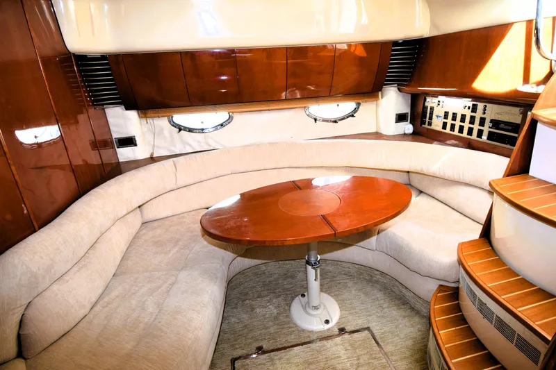 Slide: The Image of Interior of 1999 Fairline Targa 43 yacht with curved seating and wooden table. - 5