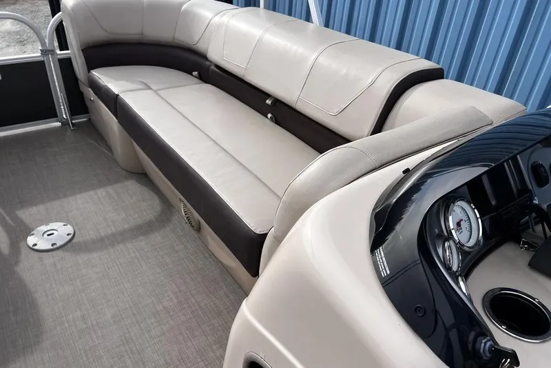 Slide: The Image of 2026 Sun Tracker Party Barge 20 DLX interior with beige seating and dashboard. - 19