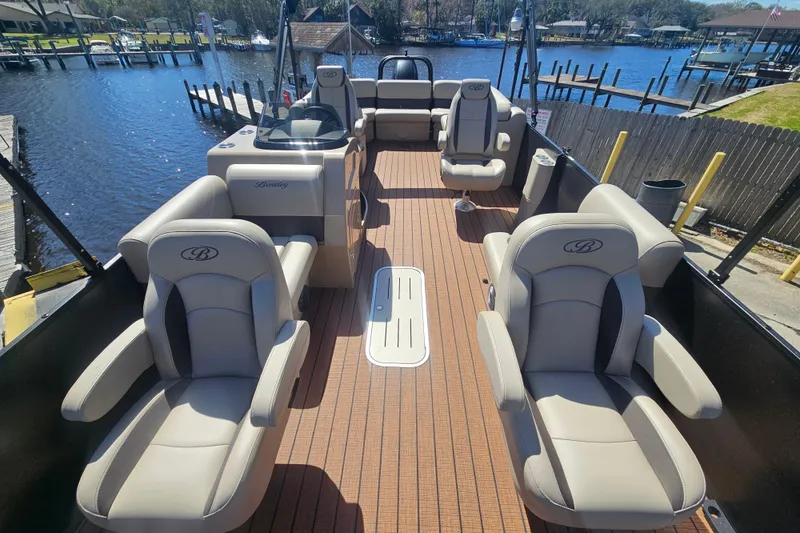 Slide: The Image of 2026 Bentley Pontoons Fish 243 Center Walk Through on a serene waterfront dock. - 14