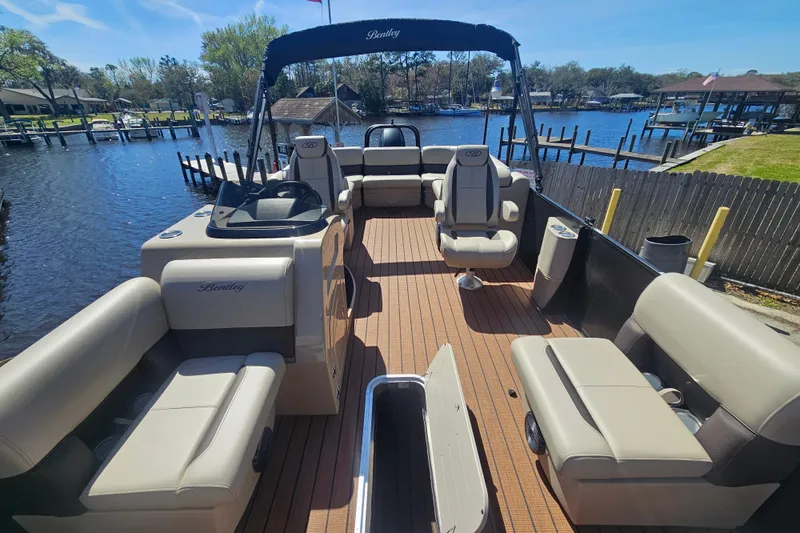 Slide: The Image of 2026 Bentley Pontoons Fish 243 Center Walk Through on a scenic waterfront. - 17
