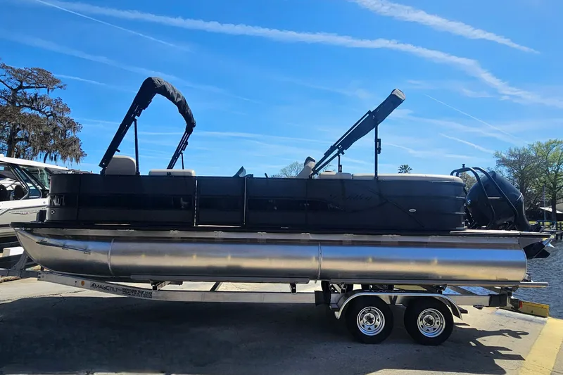 Slide: The Image of 2026 Bentley Pontoons Fish 243 Center Walk Through on trailer, under clear blue sky. - 2