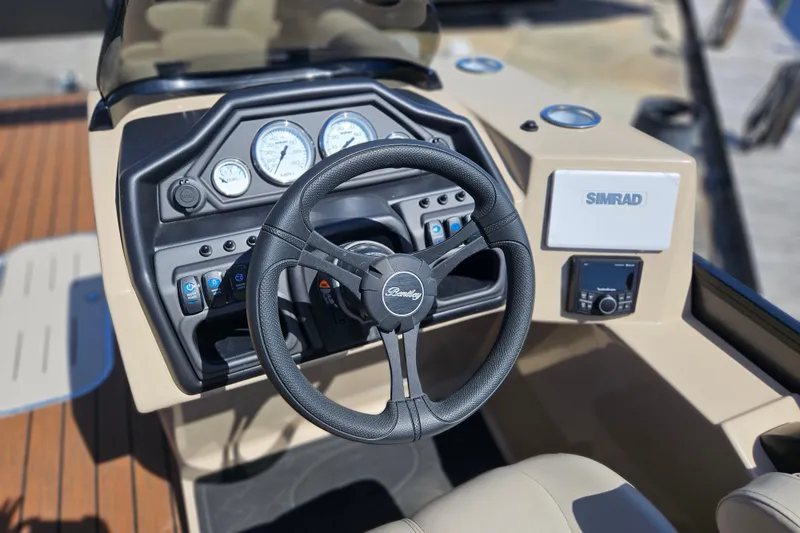 Slide: The Image of 2026 Bentley Pontoons Fish 243 Center Walk Through dashboard with steering wheel and Simrad display. - 21