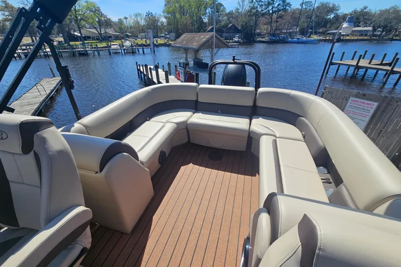 Slide: The Image of 2026 Bentley Pontoons Fish 243 Center Walk Through with spacious seating on a serene lake. - 24