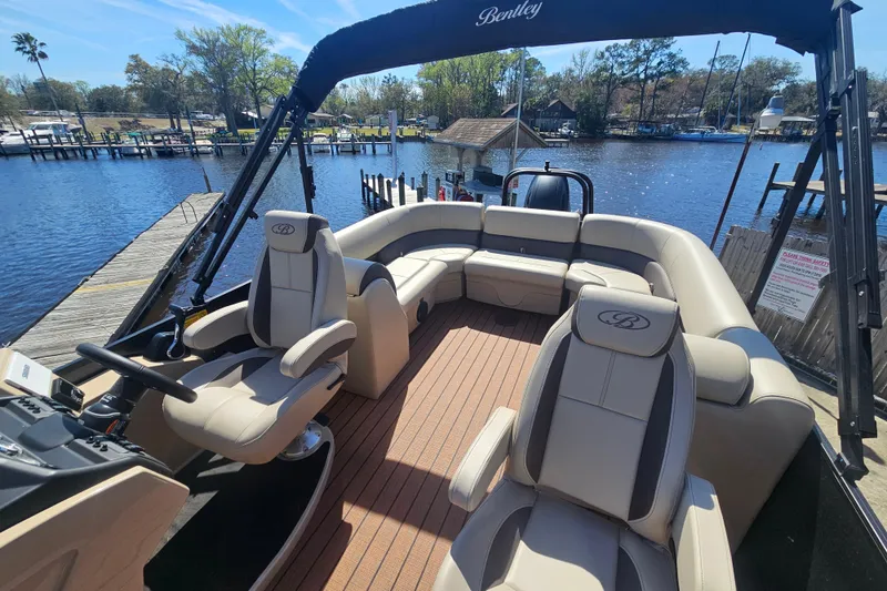 Slide: The Image of 2026 Bentley Pontoons Fish 243 Center Walk Through on a scenic waterfront dock. - 28
