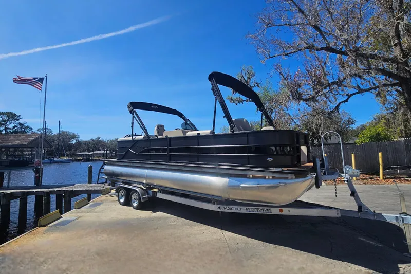 Slide: The Image of 2026 Bentley Pontoons Fish 243 Center Walk Through on trailer by a lakeside dock. - 6