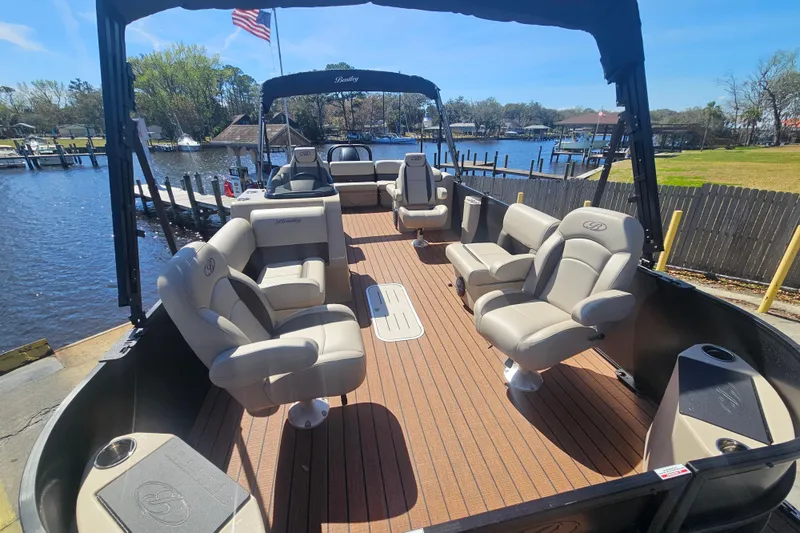 Slide: The Image of 2026 Bentley Pontoons Fish 243 Center Walk Through on a scenic waterfront dock. - 7