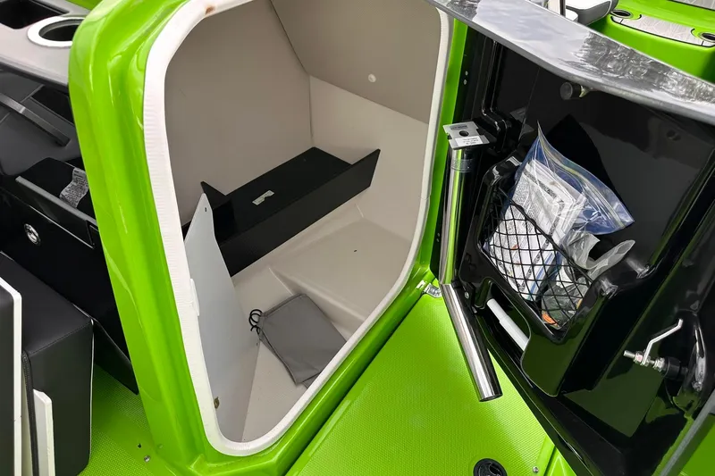 Slide: The Image of 2022 Yamaha Boats 255XD interior storage compartment with green accents and organized accessories. - 10