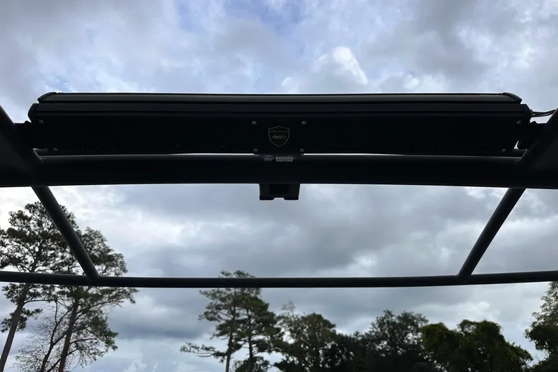 Slide: The Image of 2022 Yamaha Boats 255XD tower against cloudy sky and trees. - 15