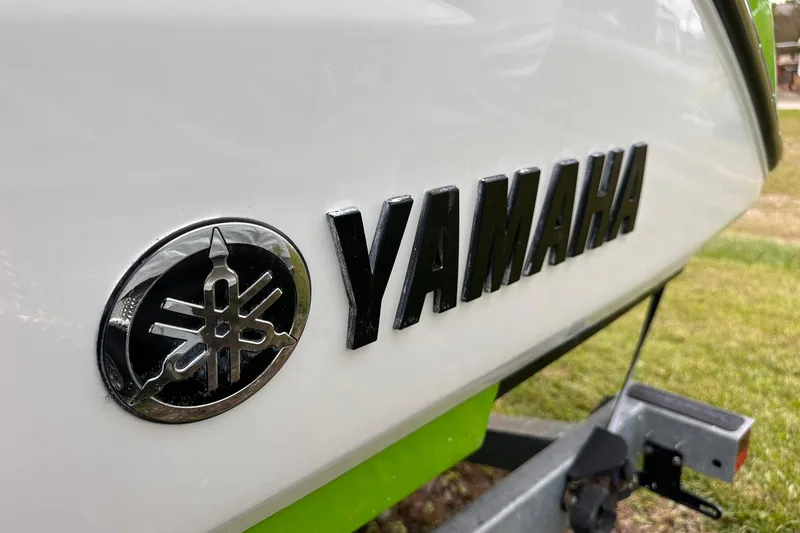 Slide: The Image of Close-up of 2022 Yamaha Boats 255XD logo on a white and green boat. - 4