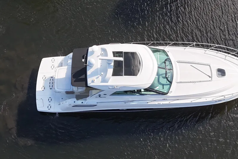 Slide: The Image of 2011 Sea Ray 450 Sundancer yacht cruising on a scenic waterway with lush greenery. - 11