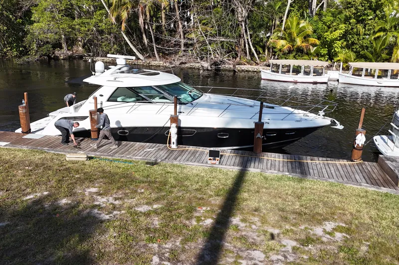 Slide: The Image of 2011 Sea Ray 450 Sundancer yacht with spacious seating and dockside view. - 23