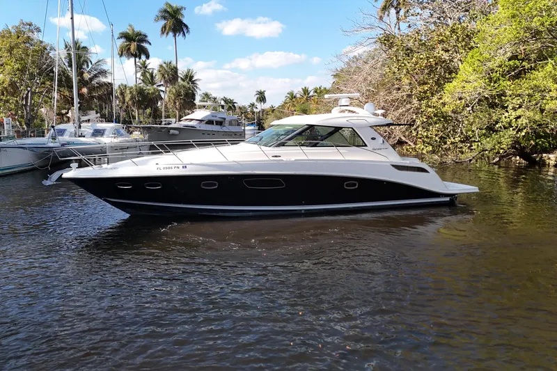 Slide: The Image of 2011 Sea Ray 450 Sundancer yacht cruising on a serene river, surrounded by lush greenery. - 4