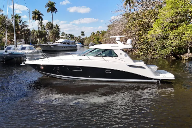 Slide: The Image of 2011 Sea Ray 450 Sundancer yacht cruising on a scenic waterway with palm trees. - 5