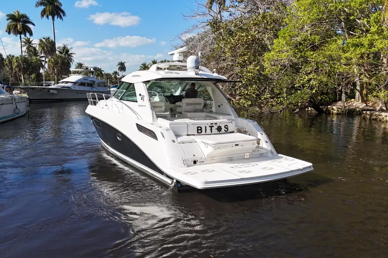 Slide: The Image of 2011 Sea Ray 450 Sundancer yacht cruising on a scenic waterway with palm trees. - 6