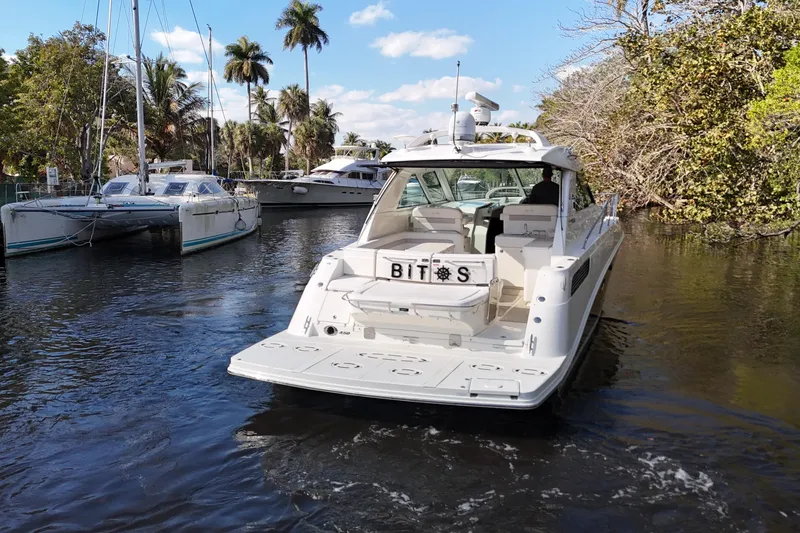 Slide: The Image of 2011 Sea Ray 450 Sundancer yacht cruising on a scenic waterway with lush greenery. - 7