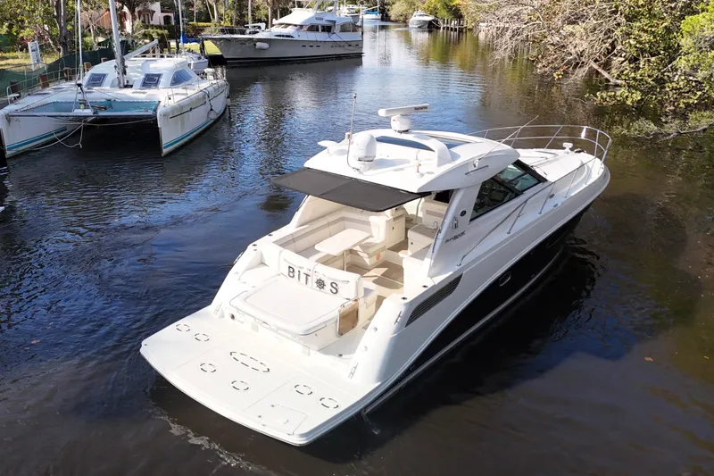 Slide: The Image of 2011 Sea Ray 450 Sundancer yacht cruising on a scenic waterway with palm trees. - 8