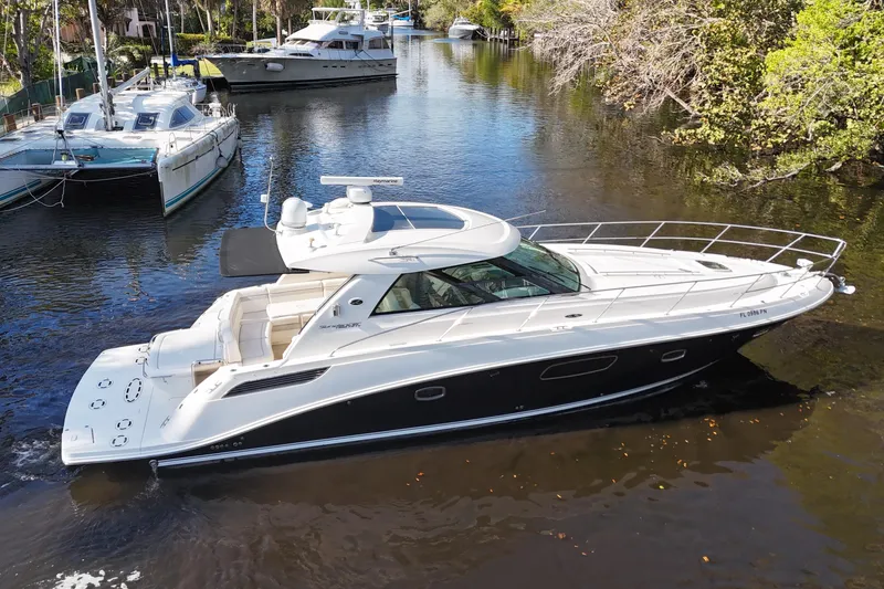 Slide: The Image of 2011 Sea Ray 450 Sundancer yacht cruising in a serene waterway. - 9