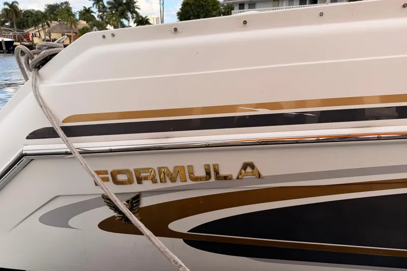 Slide: The Image of 2002 Formula 330 Sun Sport boat with gold lettering and sleek design. - 12
