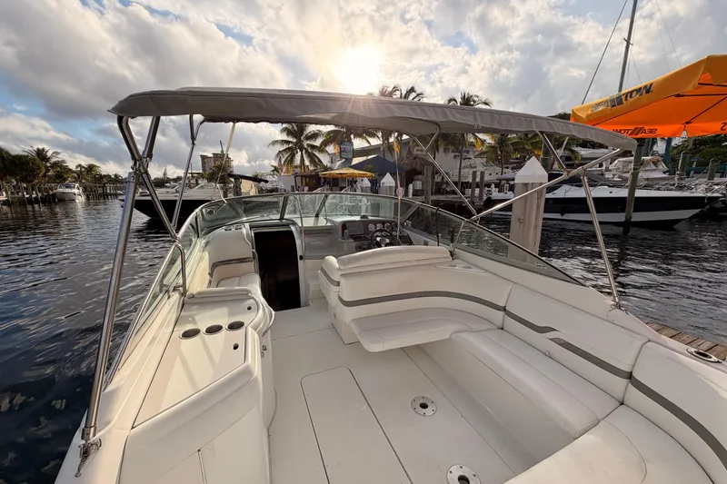 Slide: The Image of 2002 Formula 330 Sun Sport boat docked, featuring spacious seating and canopy under a sunny sky. - 20