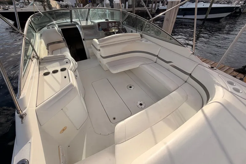 Slide: The Image of 2002 Formula 330 Sun Sport boat interior with white seating and dashboard, docked at marina. - 21