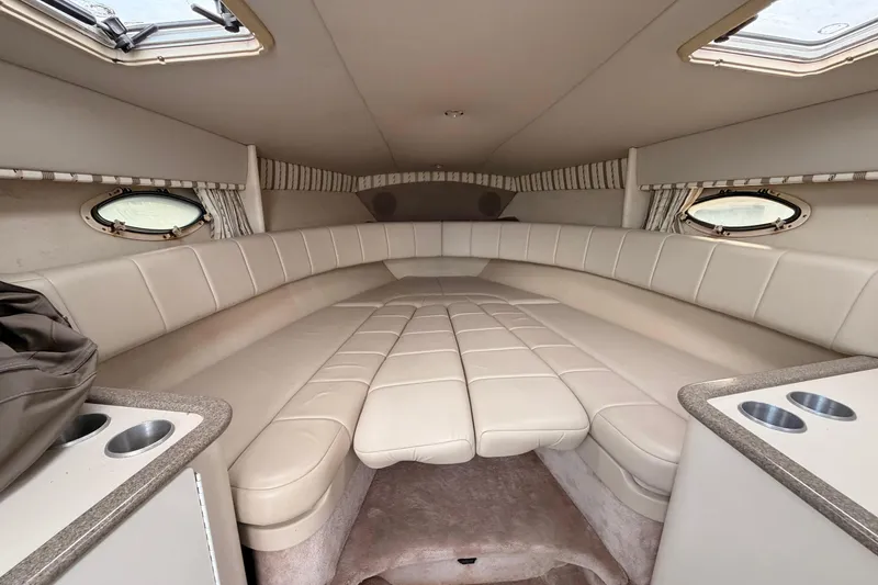 Slide: The Image of 2002 Formula 330 Sun Sport cabin interior with beige seating and porthole windows. - 43