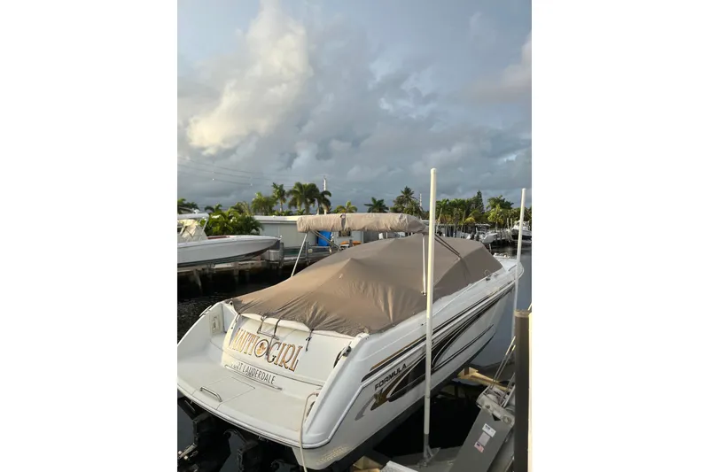 Slide: The Image of 2002 Formula 330 Sun Sport boat docked with cover, under cloudy sky. - 57