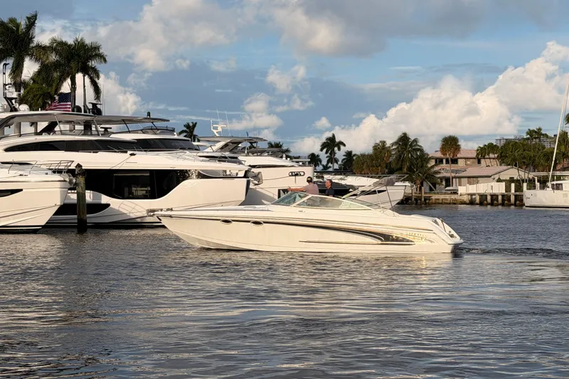Slide: The Image of 2002 Formula 330 Sun Sport boat cruising near luxury yachts and palm trees. - 64