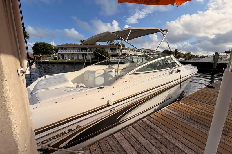 Slide: The Image of 2002 Formula 330 Sun Sport boat docked by a wooden pier under a cloudy sky. - 7