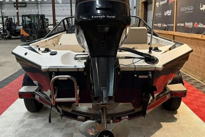 Slide: The Image of 1999 Champion 181 SX boat in a showroom, rear view with motor and ladder. - 5