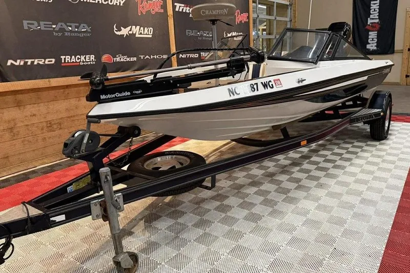 Slide: The Image of 1999 Champion 181 SX boat on trailer, displayed indoors with branded backdrop. - 7