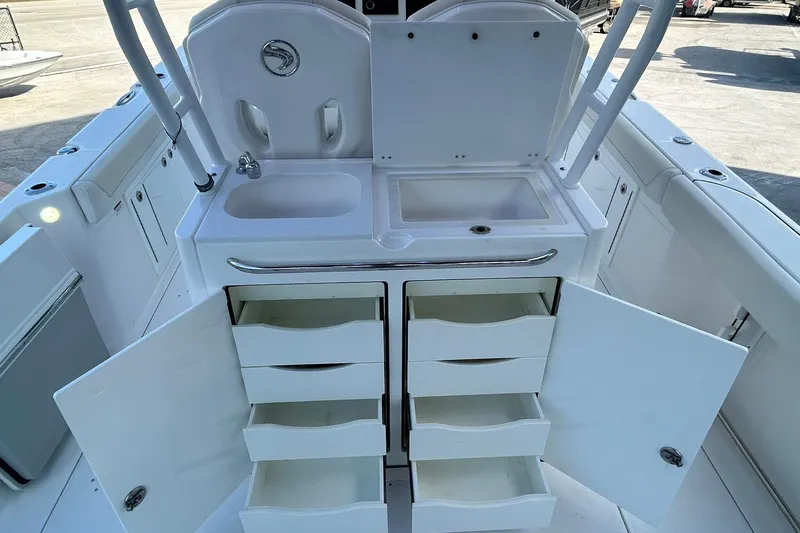 Slide: The Image of 2021 Edgewater 340CC boat interior with open storage, sink, and counter space. - 13
