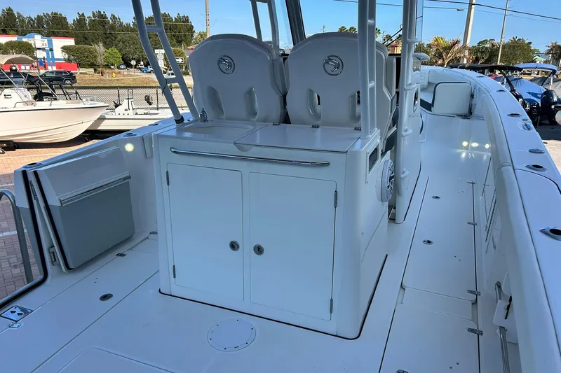 Slide: The Image of 2021 Edgewater 340CC boat interior with seating and storage compartments. - 2
