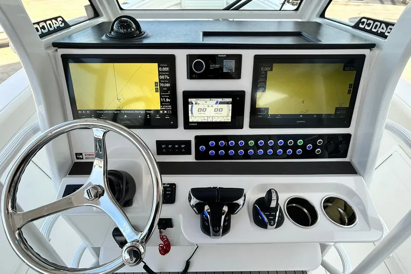 Slide: The Image of Edgewater 340CC 2021 boat dashboard with navigation screens and steering wheel. - 21