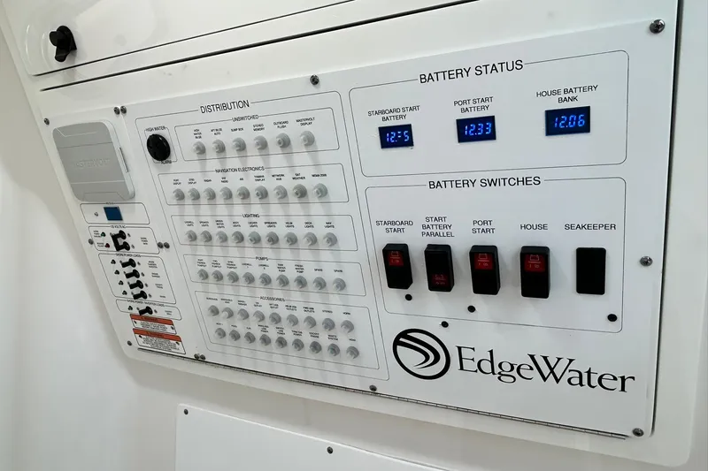 Slide: The Image of Electrical control panel of 2021 Edgewater 340CC boat, showing battery status and switches. - 27