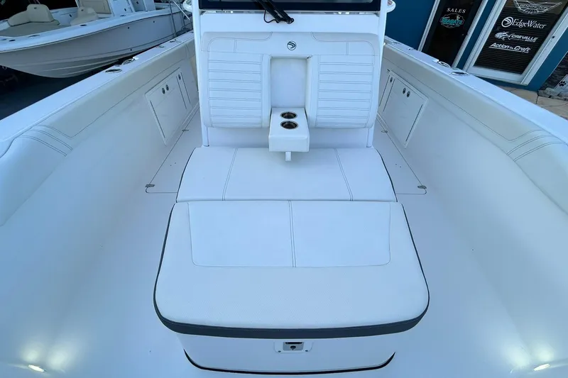 Slide: The Image of 2021 Edgewater 340CC boat interior with white seating and cup holders. - 34