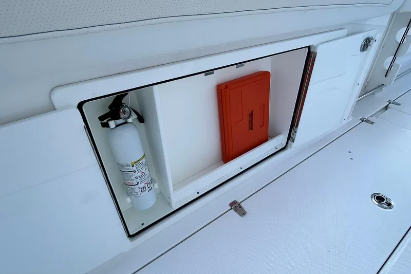Slide: The Image of Storage compartment on 2021 Edgewater 340CC boat with fire extinguisher and safety equipment. - 42