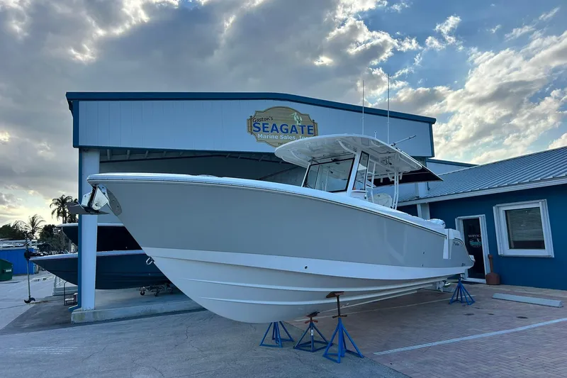 Slide: The Image of 2021 Edgewater 340CC boat displayed at Seagate Marine Sales under a cloudy sky. - 49