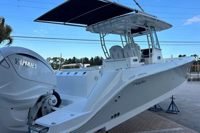 Slide: The Image of 2021 Edgewater 340CC boat with Yamaha engine, displayed outdoors on stands. - 52