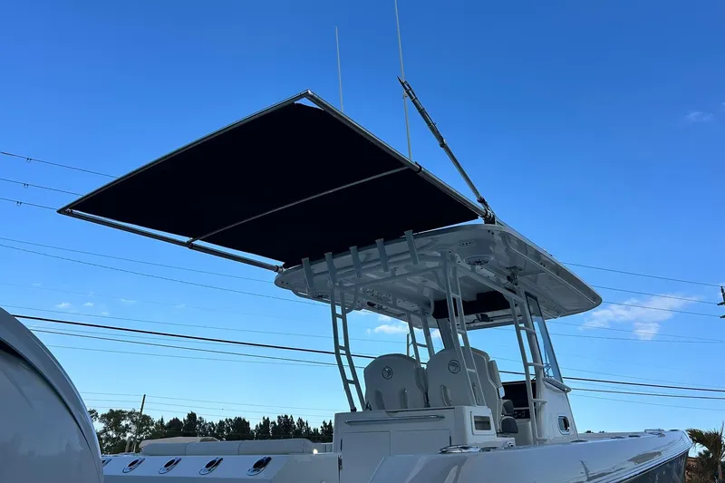 Slide: The Image of 2021 Edgewater 340CC boat with T-top against clear blue sky. - 53