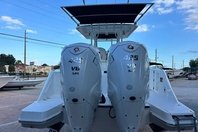 Slide: The Image of 2021 Edgewater 340CC boat with dual Yamaha 425 V8 engines, docked under blue sky. - 54
