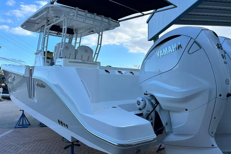 Slide: The Image of 2021 Edgewater 340CC boat with Yamaha 425 engine, docked under a blue sky. - 55