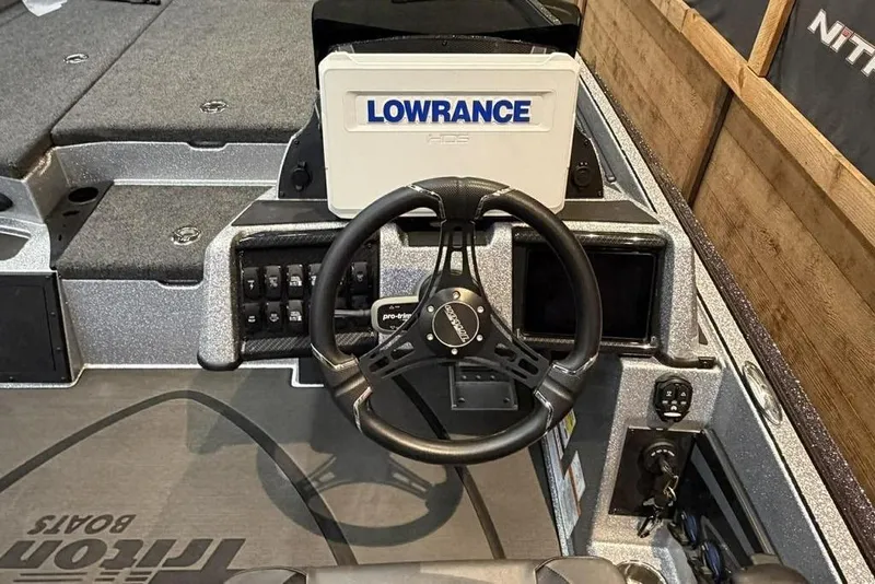 Slide: The Image of 2025 Triton 20XP Patriot boat dashboard with Lowrance GPS and steering wheel. - 5